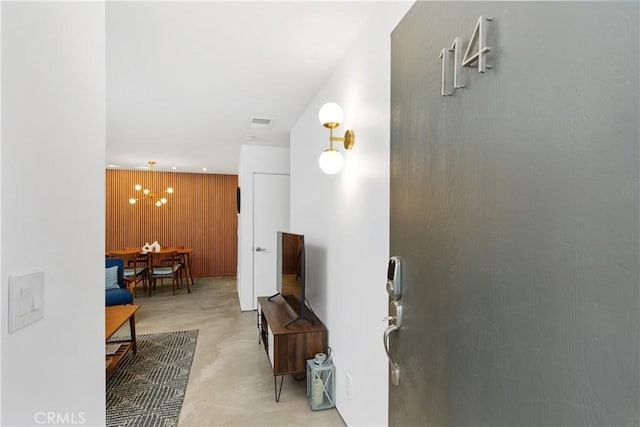 2825 N Los Felices Rd Unit 114, Palm Springs, CA 92262 - hall with concrete floors, wooden walls, and a chandelier