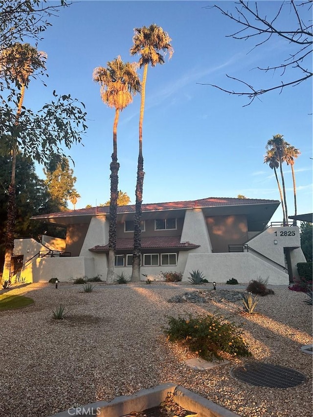 rear view of house featuring stucco siding