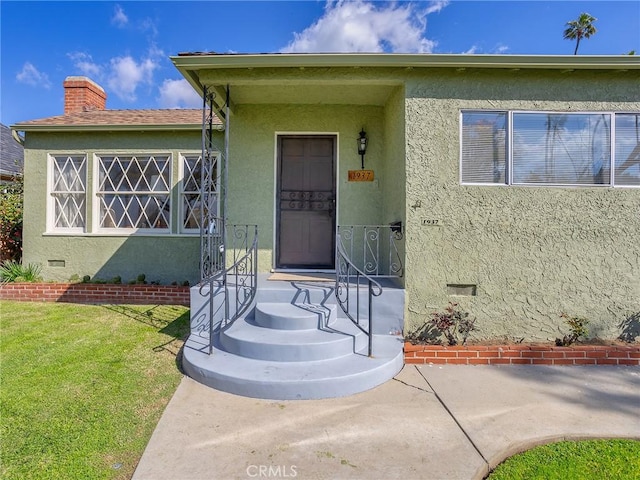 property entrance with a lawn