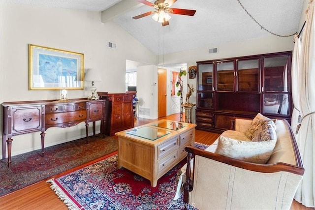 living room with hardwood / wood-style flooring, vaulted ceiling with beams, and ceiling fan