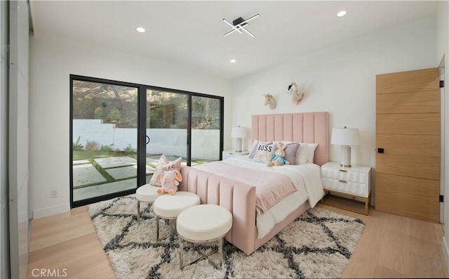 bedroom with access to exterior and light hardwood / wood-style flooring