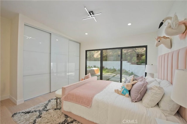 bedroom with access to exterior and light hardwood / wood-style flooring