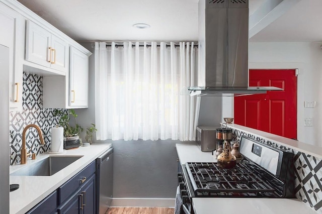 kitchen with blue cabinetry, sink, appliances with stainless steel finishes, island exhaust hood, and white cabinets