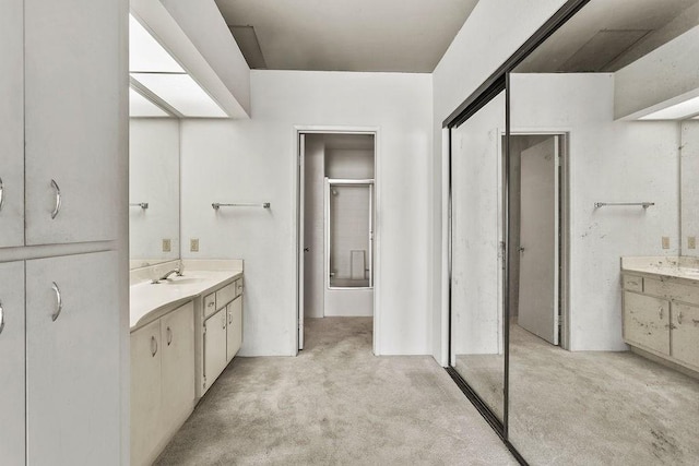 bathroom with a shower with door and vanity