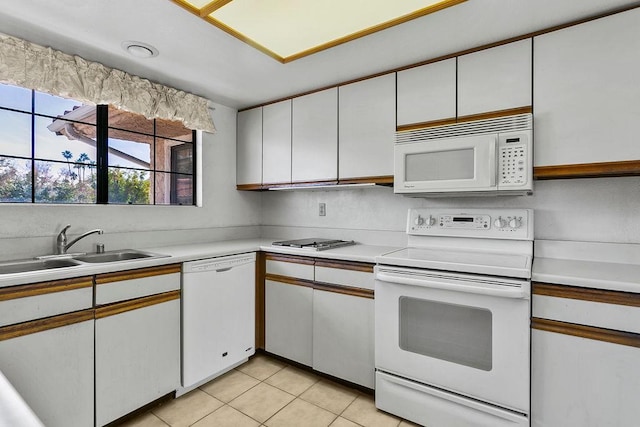 kitchen featuring white cabinetry, sink, light tile patterned floors, and white appliances