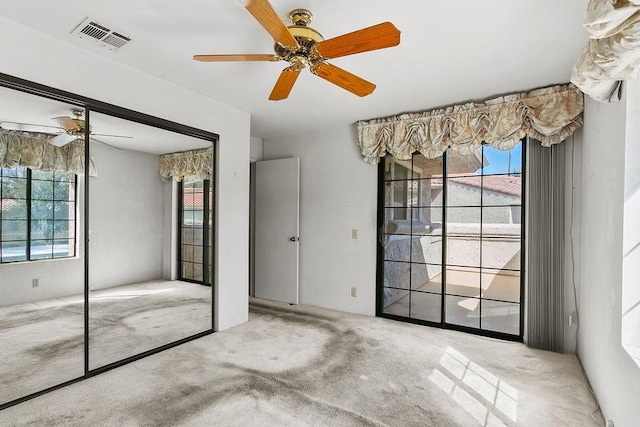 unfurnished bedroom featuring ceiling fan, light colored carpet, and a closet