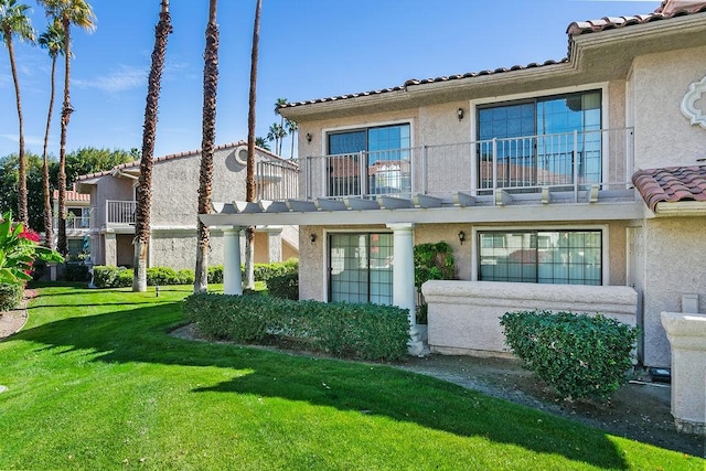 exterior space with a balcony and a yard