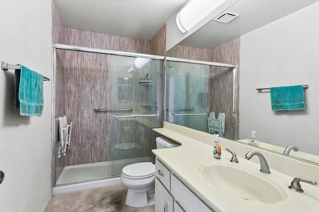 bathroom featuring a shower with door, vanity, and toilet