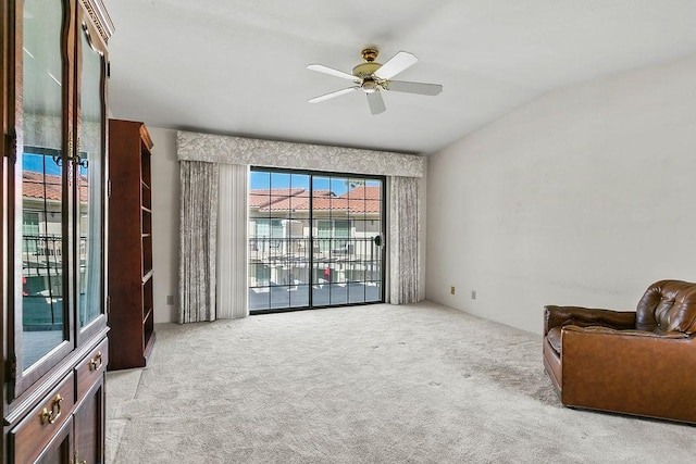 living area with ceiling fan, vaulted ceiling, and light carpet