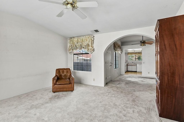 unfurnished room with lofted ceiling, a healthy amount of sunlight, light carpet, and ceiling fan