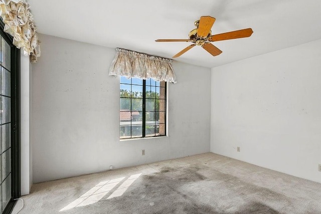 carpeted spare room with ceiling fan