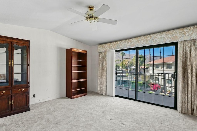 unfurnished room featuring ceiling fan, lofted ceiling, and light carpet