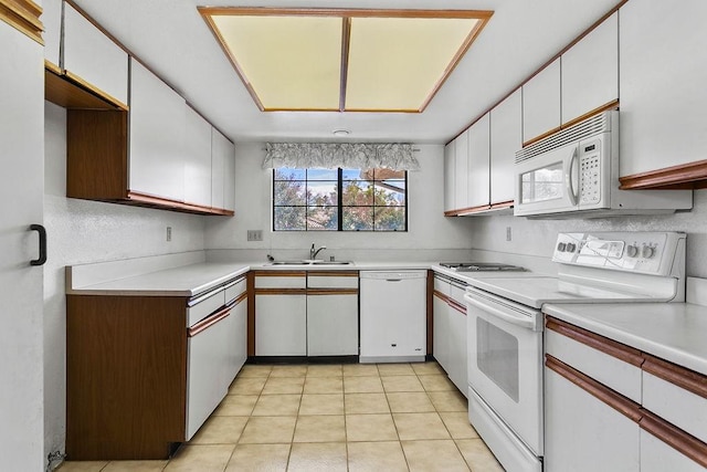 kitchen with white cabinetry, sink, light tile patterned floors, and white appliances