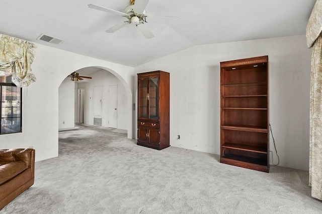 unfurnished living room with lofted ceiling, light carpet, and ceiling fan