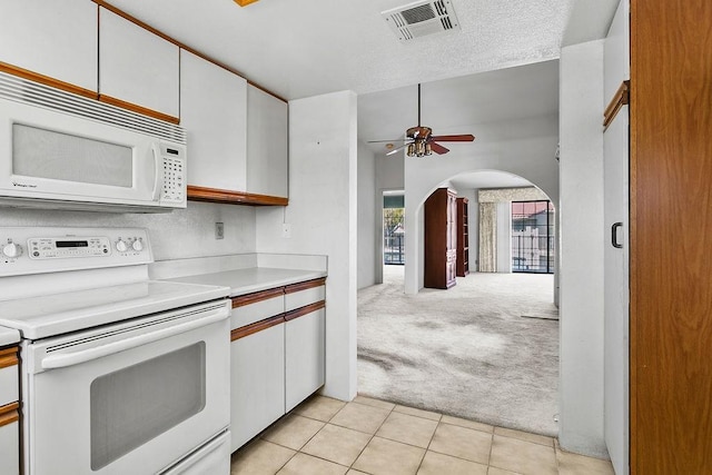 kitchen with white cabinetry, light carpet, a textured ceiling, ceiling fan, and white appliances