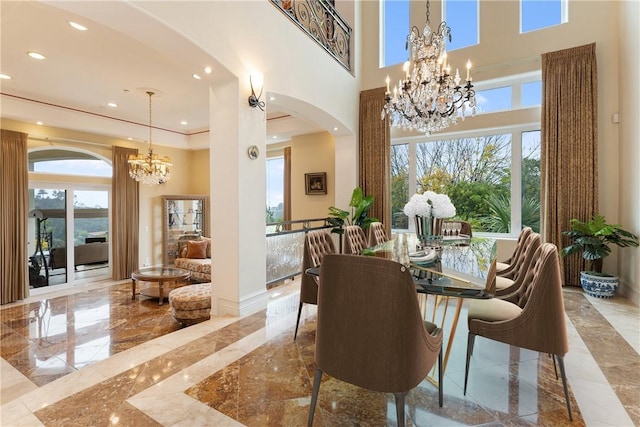 dining room with arched walkways, a notable chandelier, plenty of natural light, and marble finish floor