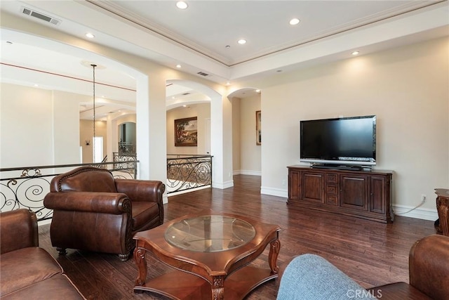 living room with arched walkways, ornamental molding, baseboards, visible vents, and dark wood-style floors