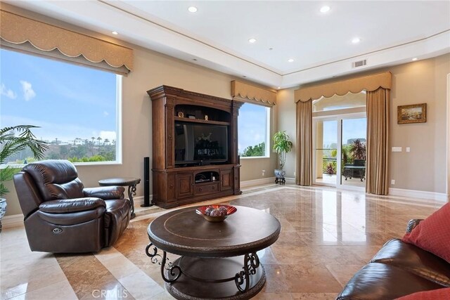 living room featuring baseboards, recessed lighting, and a wealth of natural light