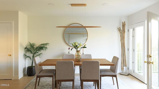 dining room with french doors and light hardwood / wood-style flooring