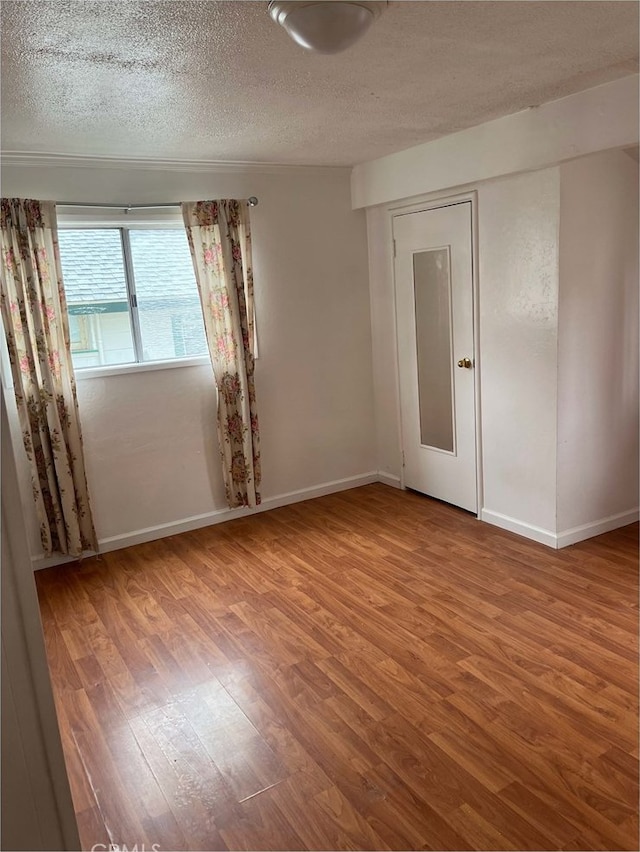 empty room featuring hardwood / wood-style floors and a textured ceiling