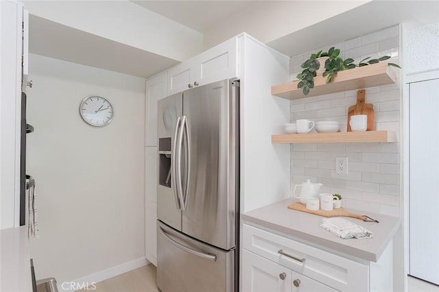 kitchen with stainless steel refrigerator with ice dispenser, white cabinetry, and tasteful backsplash