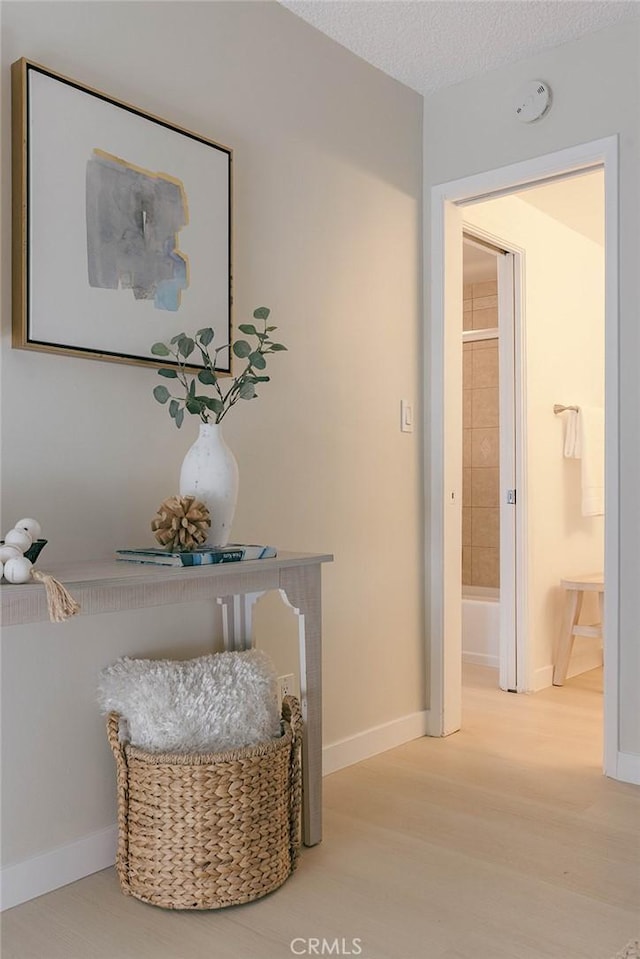 hallway with hardwood / wood-style flooring and a textured ceiling