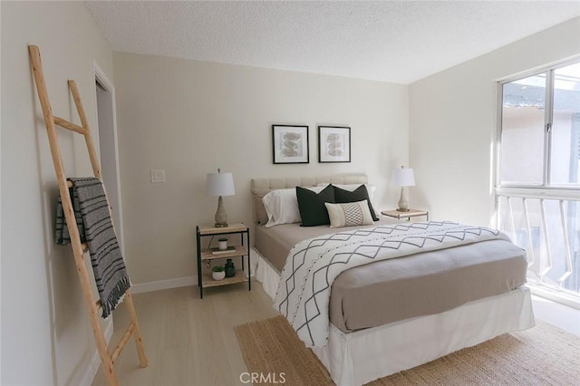 bedroom featuring a textured ceiling and light wood-type flooring