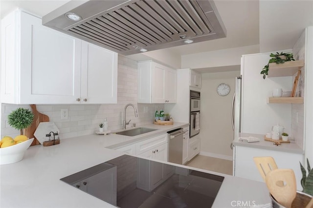 kitchen with sink, stainless steel appliances, white cabinets, decorative backsplash, and wall chimney exhaust hood