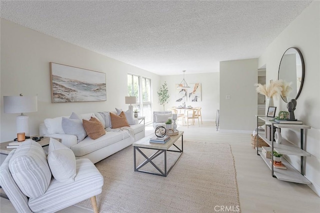 living room with a textured ceiling and light wood-type flooring