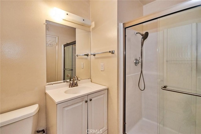 bathroom featuring vanity, toilet, and walk in shower