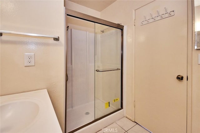 bathroom featuring tile patterned flooring and an enclosed shower