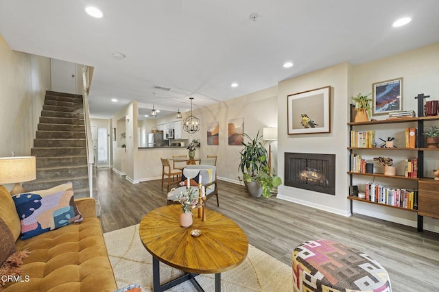 living room with an inviting chandelier and hardwood / wood-style flooring