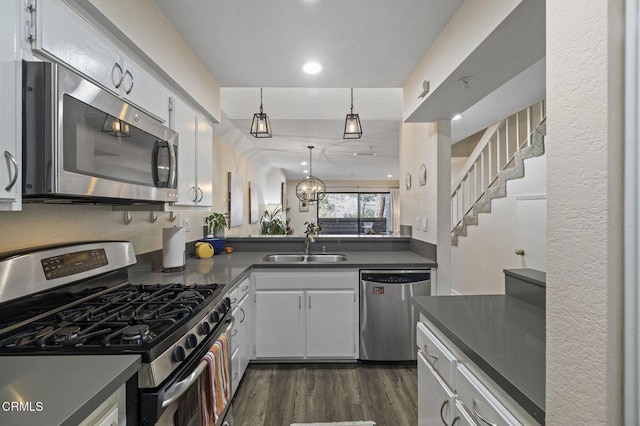 kitchen with pendant lighting, sink, white cabinets, stainless steel appliances, and dark wood-type flooring