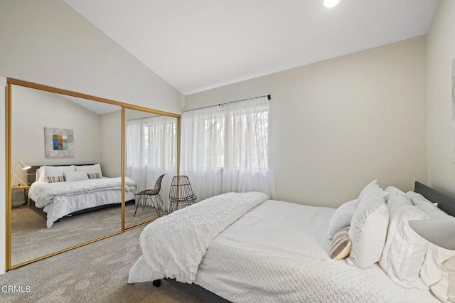 carpeted bedroom featuring vaulted ceiling and a closet