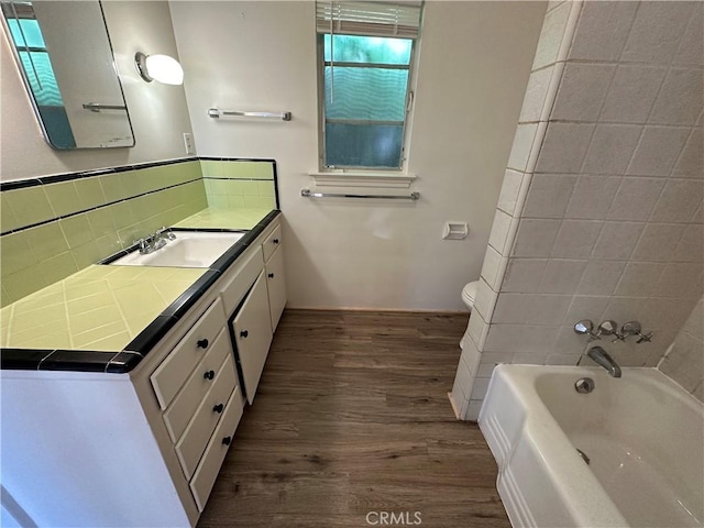 bathroom with wood-type flooring, toilet, decorative backsplash, and vanity