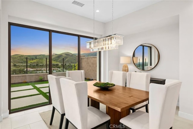 dining room featuring an inviting chandelier, a mountain view, and light tile patterned floors