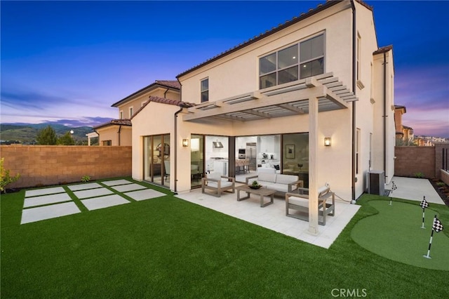 back house at dusk featuring a pergola, an outdoor hangout area, and a patio