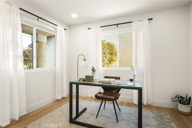 office area with baseboards, a wealth of natural light, and wood finished floors