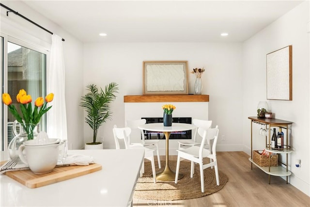 dining room featuring baseboards, recessed lighting, and light wood-style floors