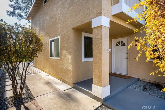 entrance to property featuring stucco siding