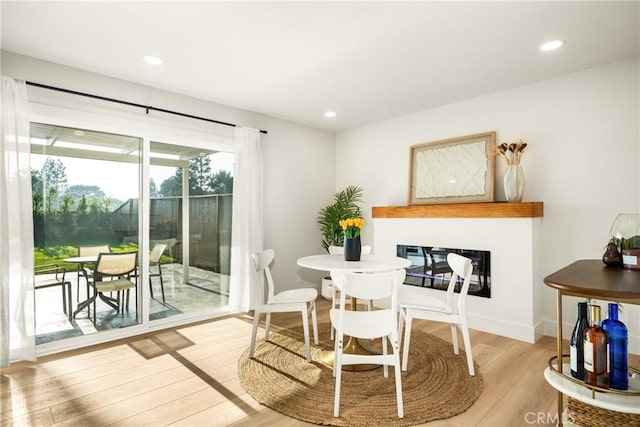 dining space with baseboards, wood finished floors, and recessed lighting