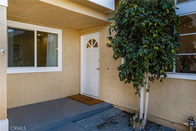 property entrance with stucco siding