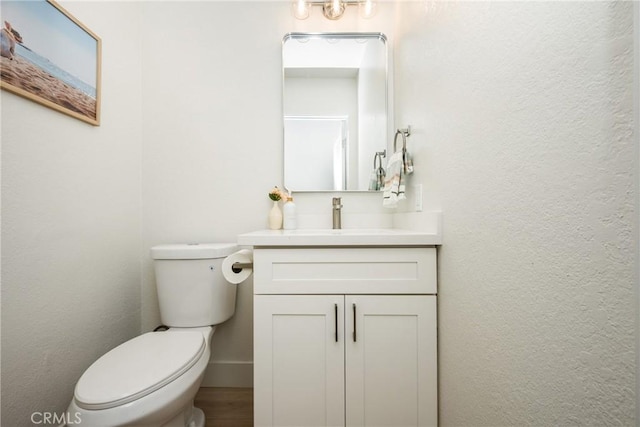 half bathroom with vanity and toilet