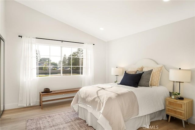 bedroom with lofted ceiling, light wood-style flooring, and recessed lighting