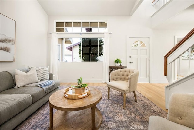 living area featuring stairs, wood finished floors, and baseboards