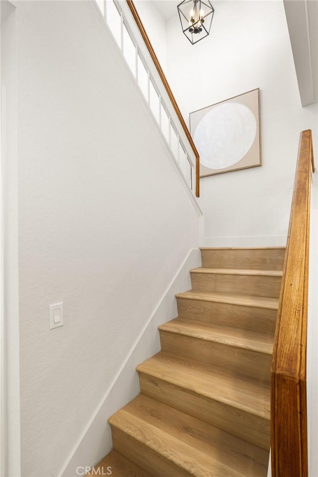 staircase with a chandelier