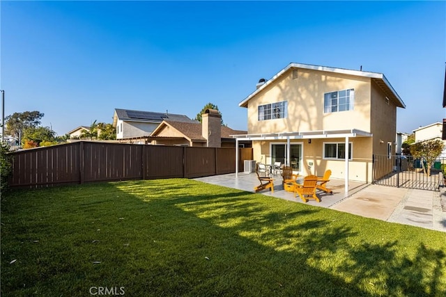 rear view of house with a patio area, stucco siding, a lawn, and a fenced backyard