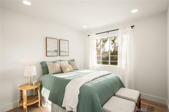 bedroom featuring baseboards, wood finished floors, and recessed lighting