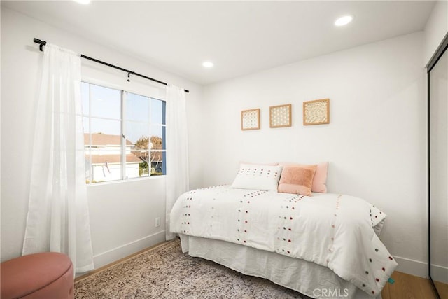 bedroom featuring baseboards, a closet, and recessed lighting