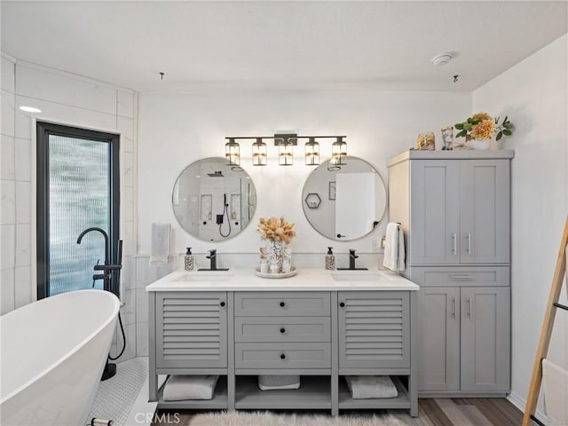 full bathroom featuring a sink, double vanity, and a freestanding tub